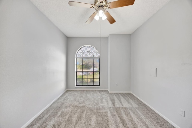 carpeted spare room with ceiling fan and a textured ceiling