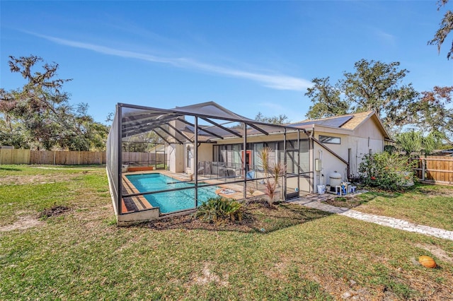 view of swimming pool with glass enclosure and a lawn