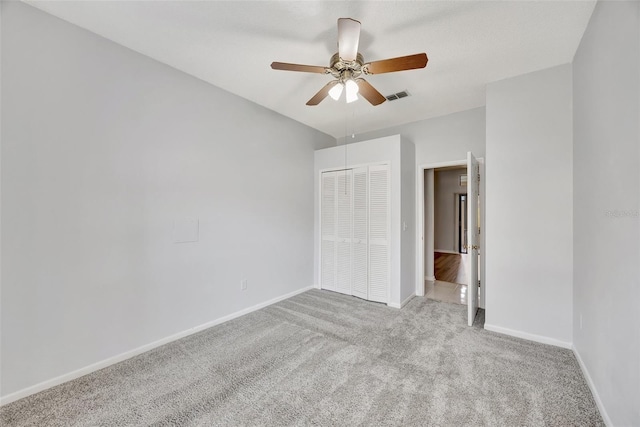 unfurnished bedroom featuring light carpet, ceiling fan, and a closet