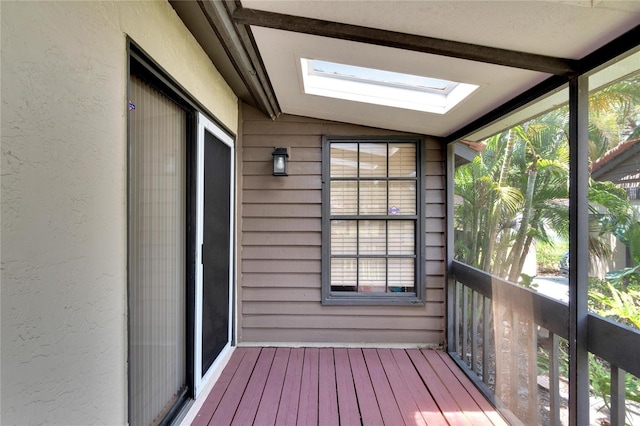 unfurnished sunroom featuring lofted ceiling with skylight and a wealth of natural light