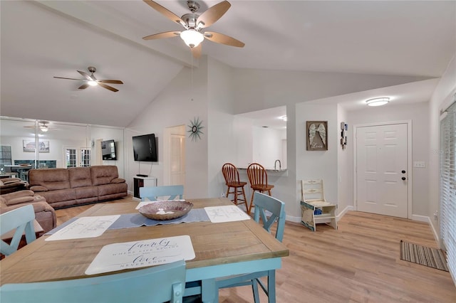 dining room with beamed ceiling, high vaulted ceiling, and light wood-type flooring