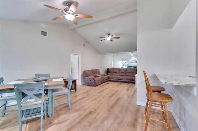 dining space with lofted ceiling with beams, light hardwood / wood-style floors, and ceiling fan