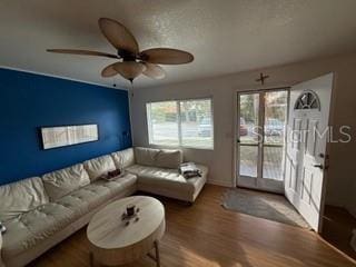 living room featuring hardwood / wood-style floors and ceiling fan