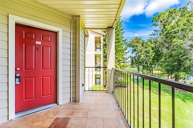 entrance to property featuring a lawn and a balcony