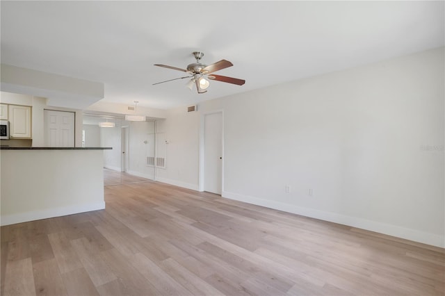 unfurnished living room featuring light hardwood / wood-style flooring and ceiling fan