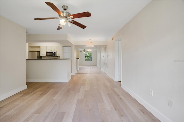 unfurnished living room featuring ceiling fan and light hardwood / wood-style flooring