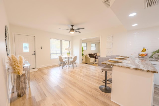 unfurnished dining area featuring ceiling fan and light hardwood / wood-style flooring