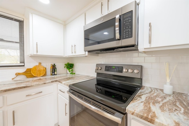 kitchen with white cabinets, stainless steel appliances, and light stone counters