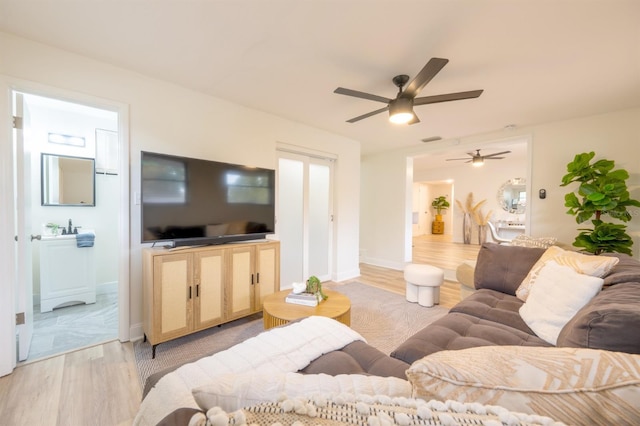 living room featuring light hardwood / wood-style floors and ceiling fan