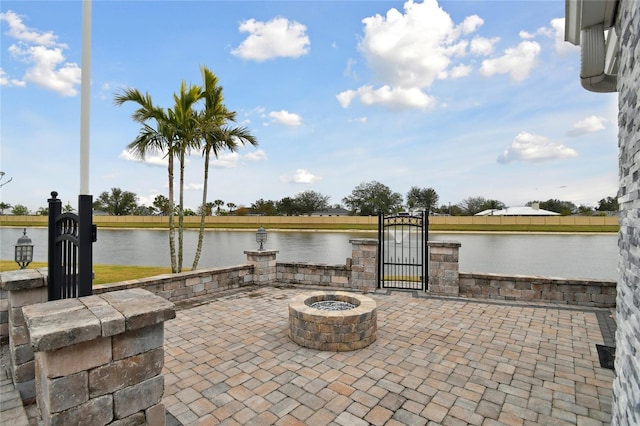 view of patio / terrace with an outdoor fire pit and a water view