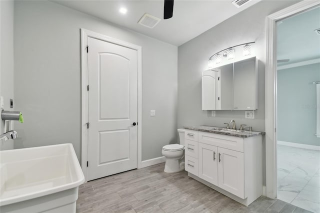 bathroom featuring toilet, ceiling fan, and vanity