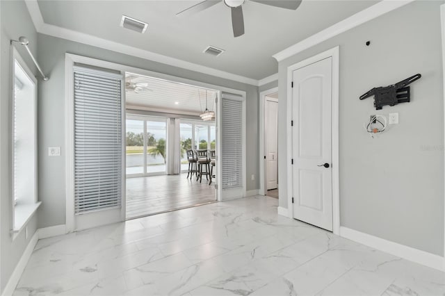 empty room featuring ceiling fan and crown molding