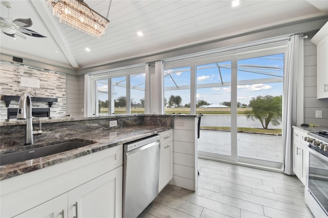 kitchen featuring sink, white cabinetry, stainless steel appliances, and a water view