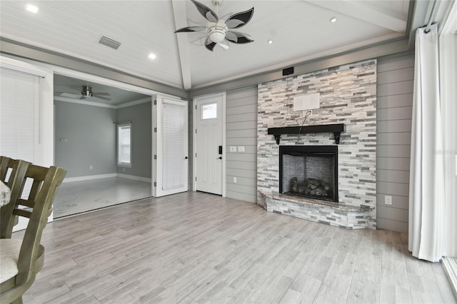 living room with vaulted ceiling, a fireplace, ornamental molding, light hardwood / wood-style flooring, and ceiling fan