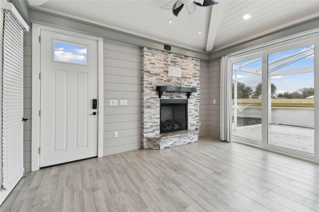 unfurnished living room featuring light hardwood / wood-style floors, vaulted ceiling, wood ceiling, and a fireplace