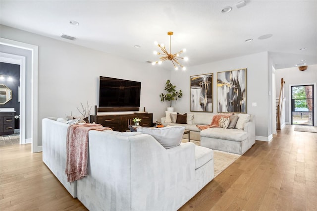 living room with a notable chandelier and light hardwood / wood-style floors