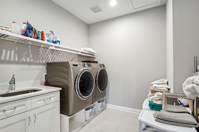 washroom featuring cabinets, washing machine and dryer, sink, and light tile patterned floors