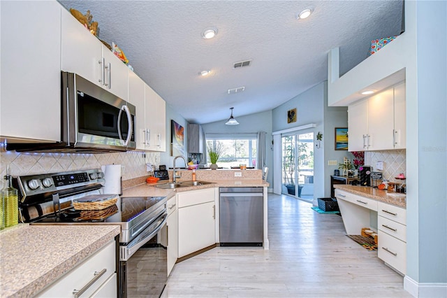 kitchen featuring stainless steel appliances, kitchen peninsula, and white cabinets