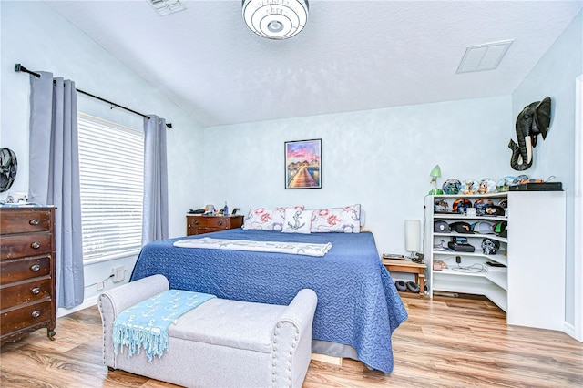 bedroom with a textured ceiling and light wood-type flooring