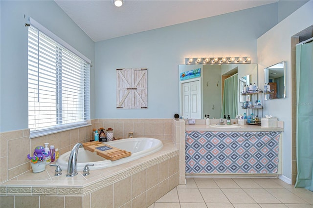 bathroom featuring tiled tub, vanity, and tile patterned floors