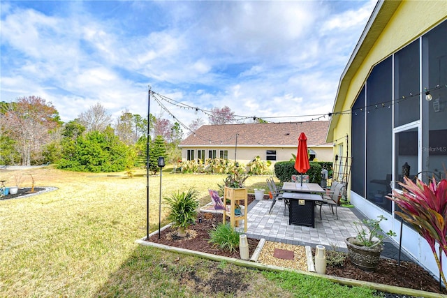 view of yard with a sunroom and a patio