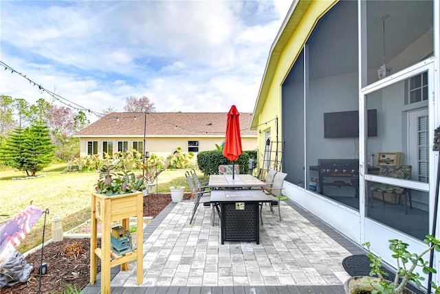 view of patio / terrace with a sunroom and a grill