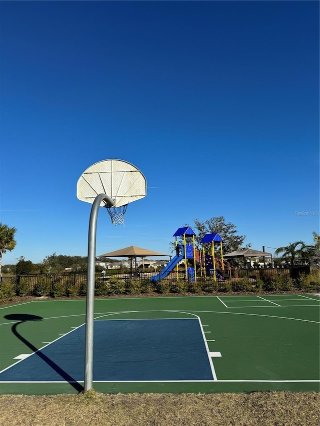 view of basketball court featuring a playground