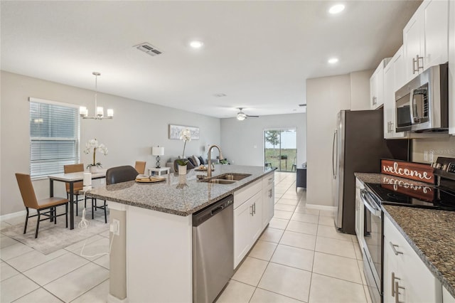 kitchen featuring sink, stainless steel appliances, white cabinets, and a kitchen island with sink