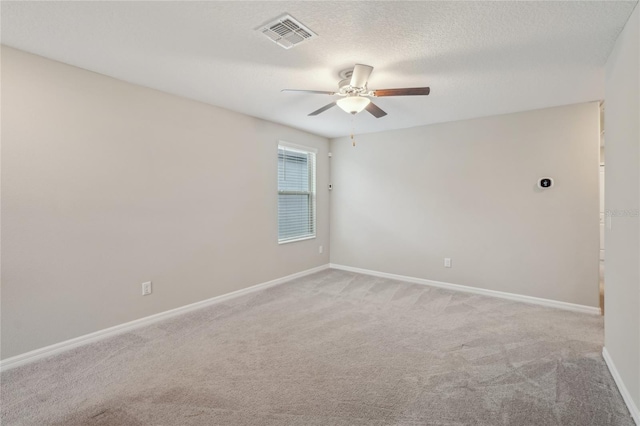 unfurnished room with ceiling fan, light colored carpet, and a textured ceiling