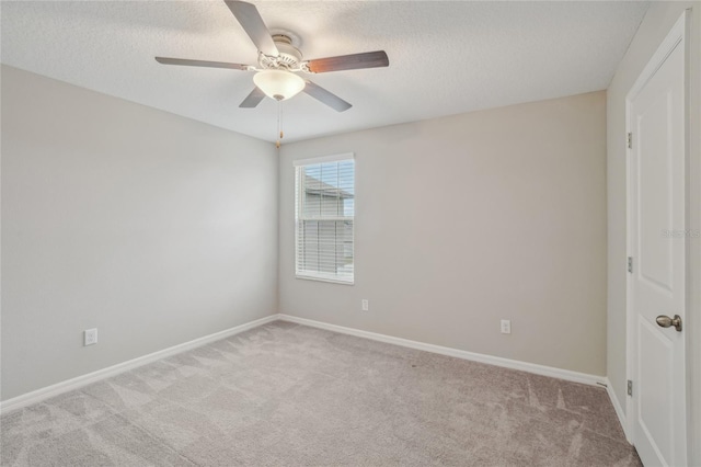 spare room featuring light carpet, a textured ceiling, and ceiling fan