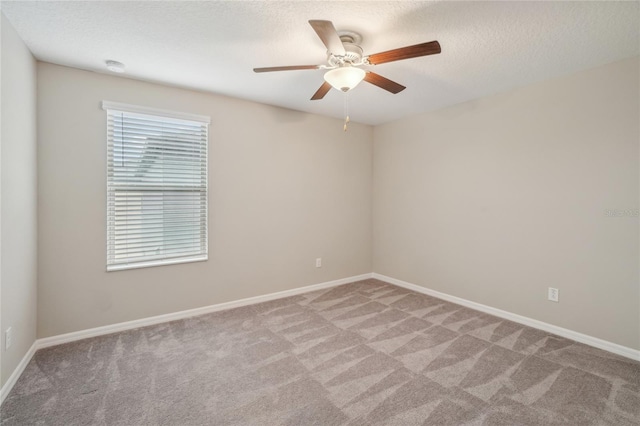 carpeted spare room featuring a textured ceiling and ceiling fan