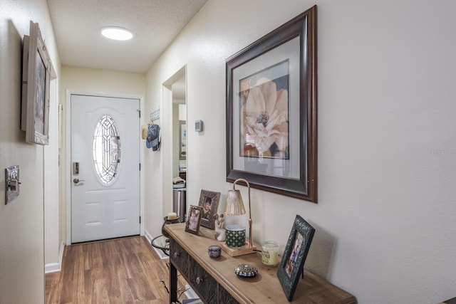 doorway to outside with a textured ceiling and wood-type flooring