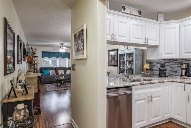 kitchen with sink, stainless steel dishwasher, white cabinetry, and a textured ceiling