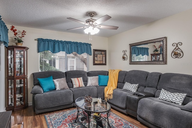 living room featuring hardwood / wood-style flooring, a textured ceiling, and ceiling fan