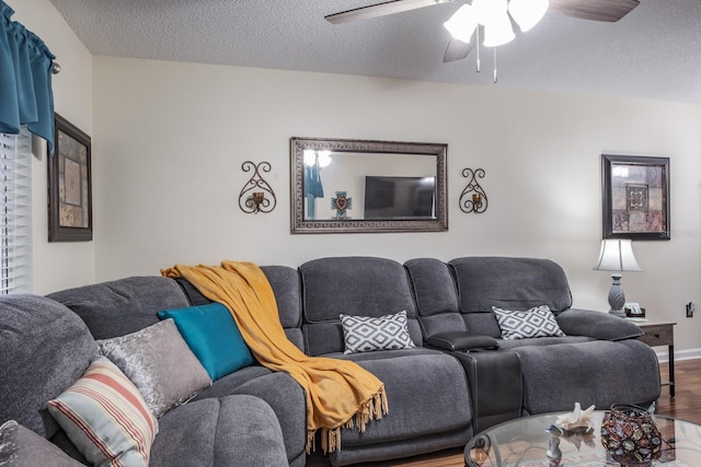 living room featuring wood-type flooring, a textured ceiling, and ceiling fan