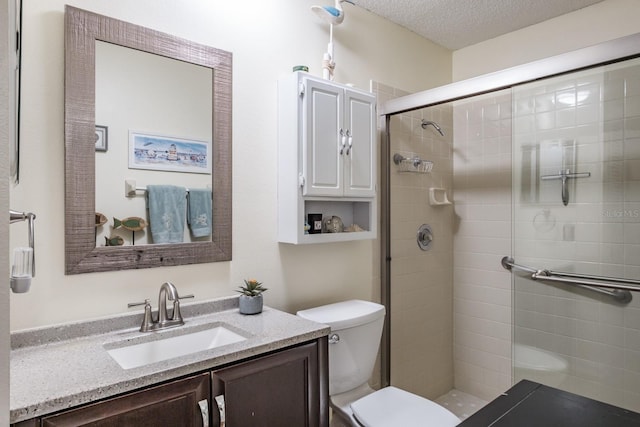 bathroom with a textured ceiling, toilet, vanity, and walk in shower