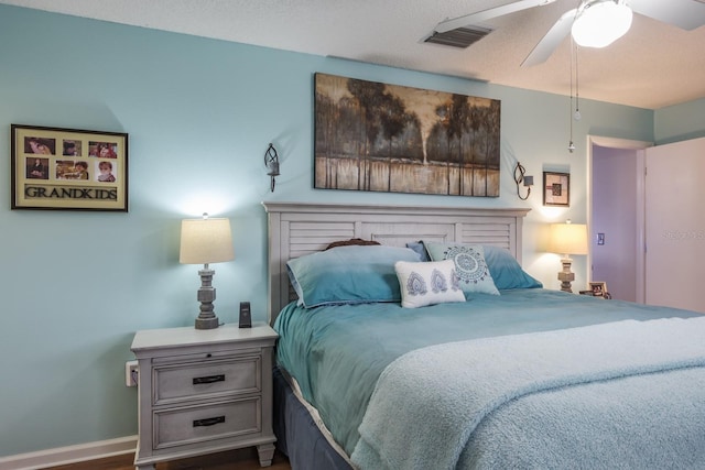 bedroom featuring ceiling fan, dark hardwood / wood-style floors, and a textured ceiling