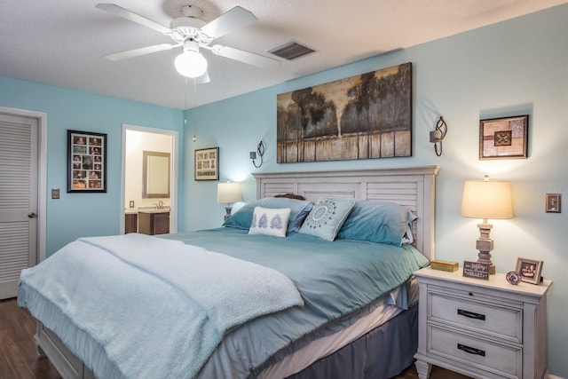 bedroom with sink, ensuite bath, ceiling fan, and dark hardwood / wood-style flooring