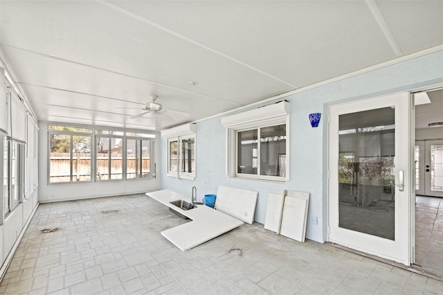 unfurnished sunroom featuring ceiling fan