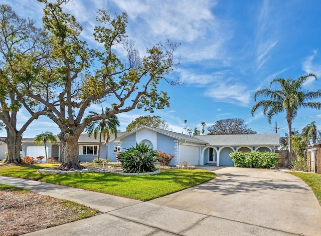 ranch-style home with a garage and a front lawn