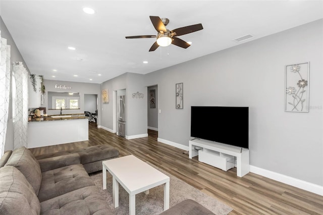 living room with ceiling fan, dark wood-type flooring, and sink