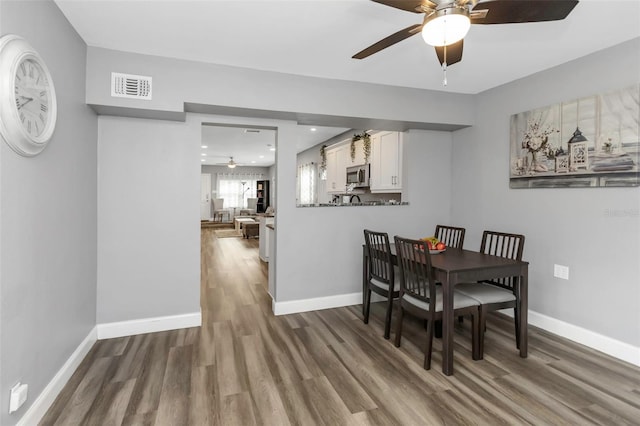 dining space featuring ceiling fan and wood-type flooring