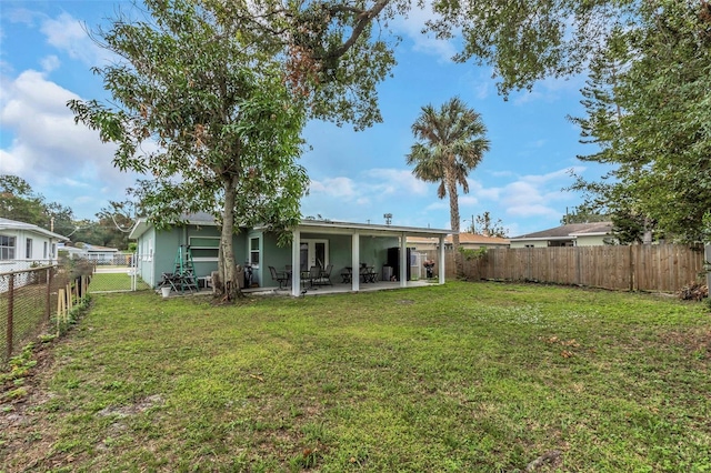 rear view of house with a patio area and a lawn