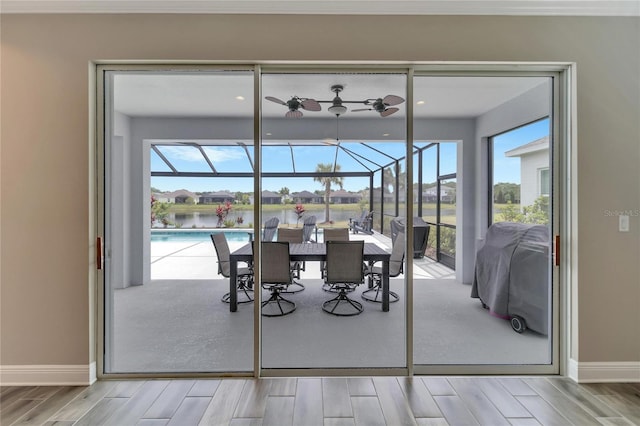 unfurnished dining area with a healthy amount of sunlight, a water view, and ceiling fan