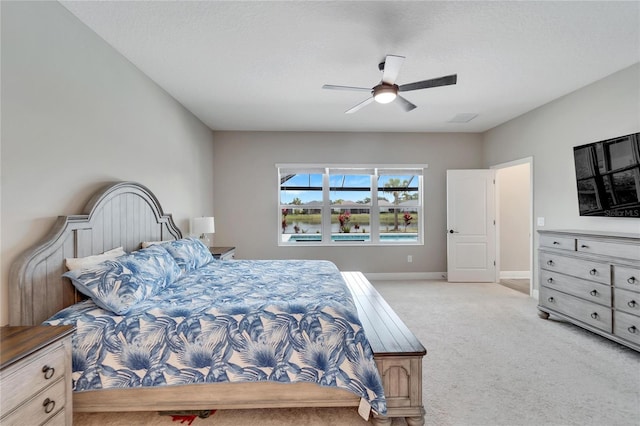 bedroom featuring ceiling fan, a textured ceiling, and light carpet