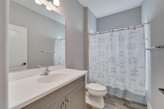 bathroom featuring hardwood / wood-style flooring, toilet, and vanity