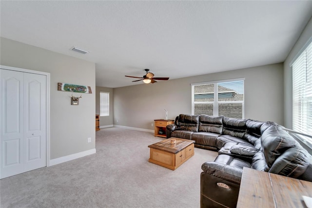 carpeted living room with ceiling fan