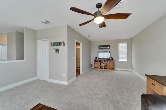 unfurnished living room with ceiling fan and light carpet