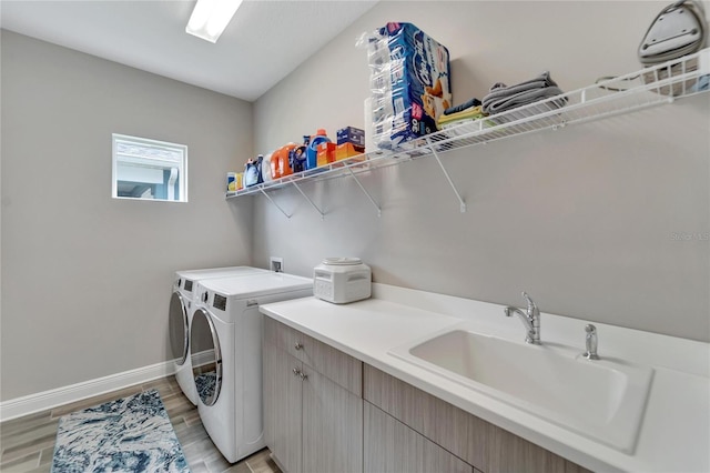 laundry room with cabinets, separate washer and dryer, light hardwood / wood-style flooring, and sink