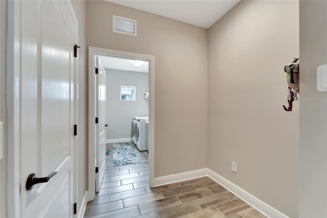 corridor featuring washing machine and dryer and light hardwood / wood-style flooring